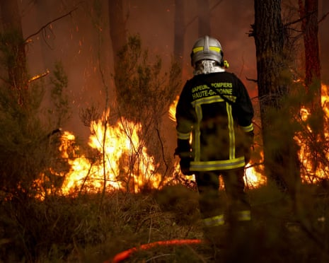 A firefighter stands before flames as a forest fire rages in Saint-Jean-d'Illac, some 30km from Bordeaux, France.