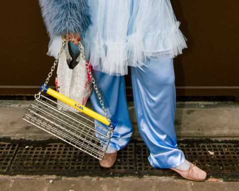 A person holding a bag made of the top part of a Lidl shopping trolley