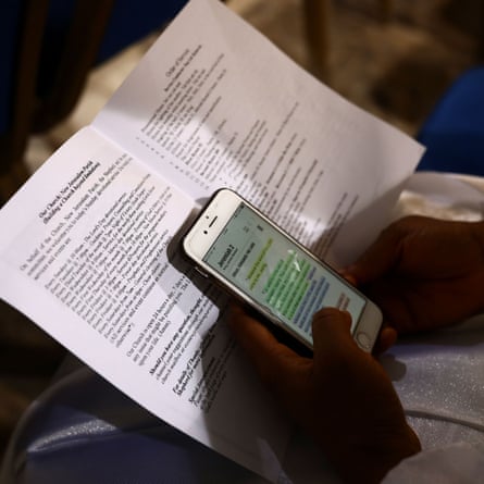 A worshipper reads a passage from the Bible on her smartphone during a Sunday service at the New Jerusalem Parish