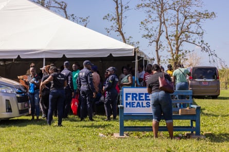 people stand in grassy area by tent