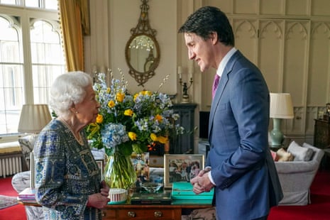 The British queen and the Canadian prime minister gaze at each other.
