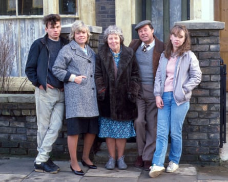 Five people stand outside a house in a promo shot from EastEnders