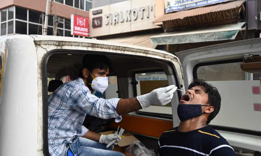 A health worker collects a swab sample from a man to test for Covid-19 in Gurgaon, India.