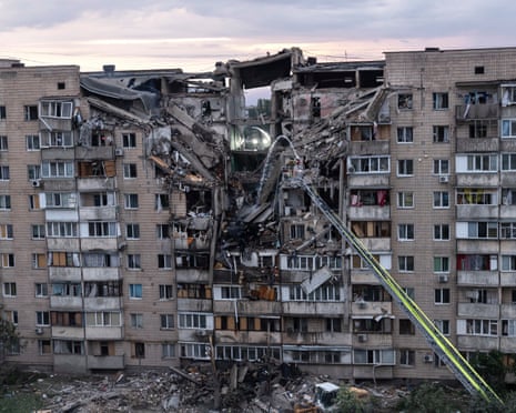 Firefighters work on a partially collapsed building at the scene of an attack as Russian missiles and drones struck Kyiv overnight on Monday.