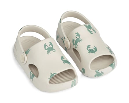 A side view of Liewood Morris Sandals which have a back ankle strap and small crab motifs in teal printed on the ecru body.