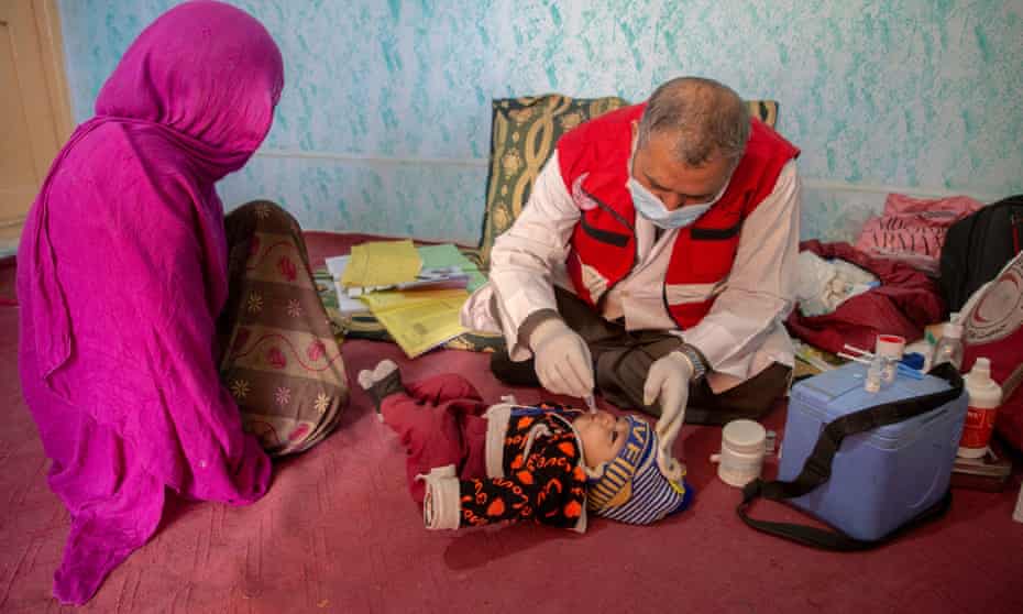 A child is examined by a doctor from the Afghan Red Crescent mobile health team