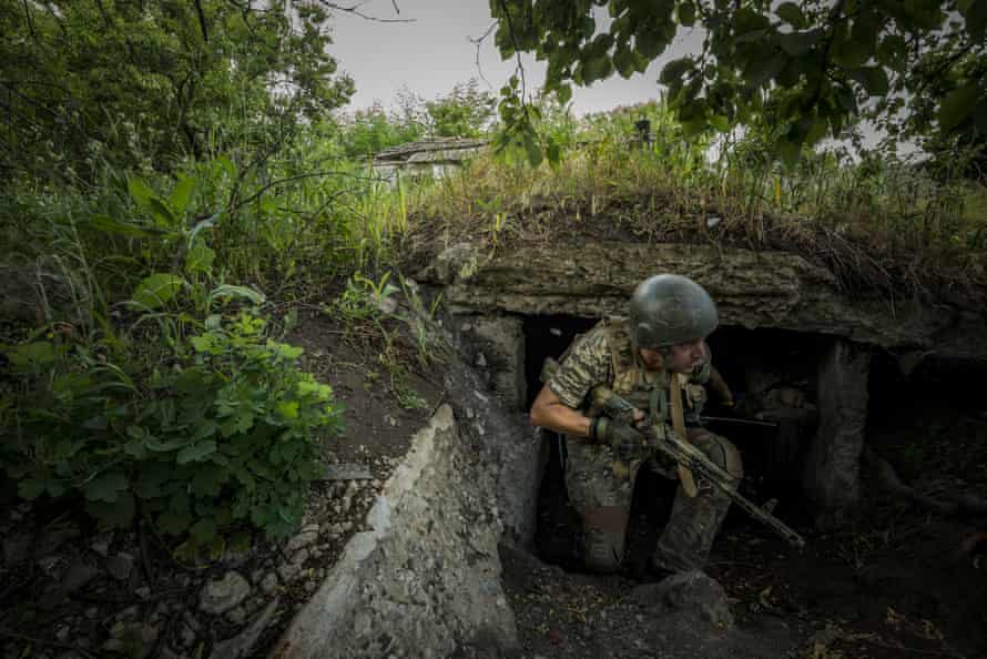 A Ukrainian soldier covers himself in his bunker during shelling between the Russian and Ukrainian forces in the frontline of Zaporizhzhia, Ukraine.