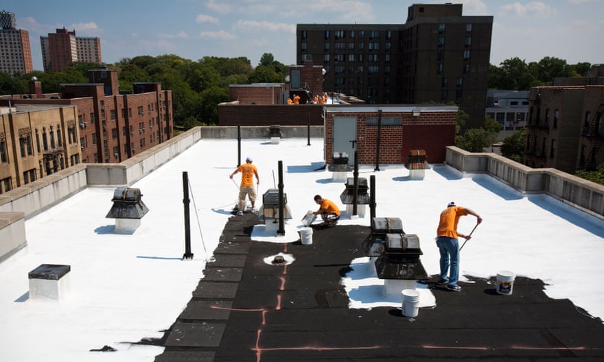 Volunteers paint a roof in New York with reflective material. Light-coloured roofs can lower the overall temperature of a city as well as individual residences.