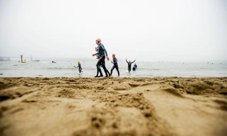 Swimmers emerge from San Francisco Bay following a swim.