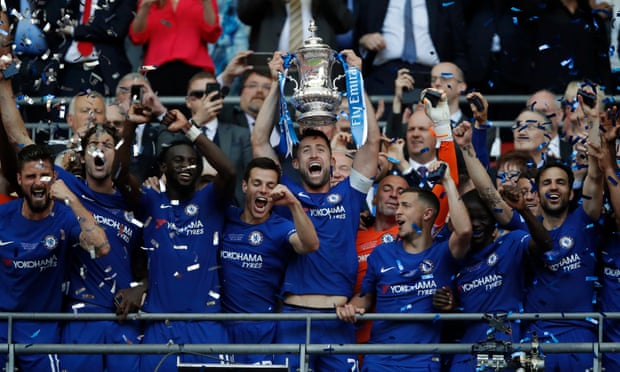Gary Cahill lifts the trophy as the Chelsea players celebrate.