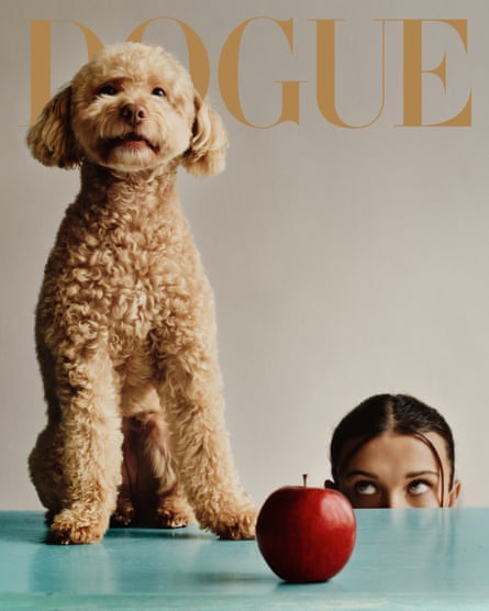 Winnie stood on a table with an apple on it, with Millie Bobby Brown’s face just peeking above the table in the background