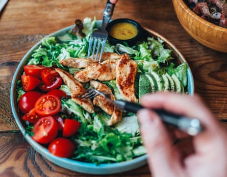A bowl of mixed salad and pieces of chicken