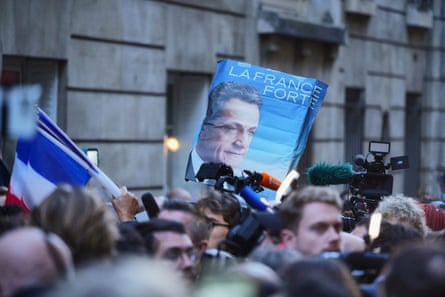 Supporters of Sarkozy wave a photo from an old election campaign