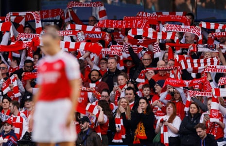 Arsenal fans hold up their scarves in the stands before kick-off at Stamford Bridge.
