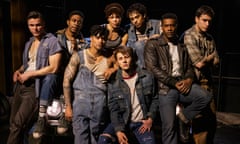 Eight people, wearing various outfits of denim, leather and plaid, pose together