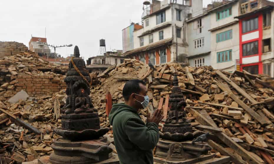 A man prays next to rubble of a temple, destroyed in Saturday’s earthquake, in Kathmandu.