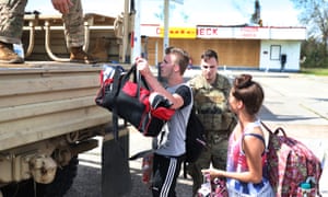 Caleb Daigle and Cloe Cuvilliara are evacuated by Louisiana national guard members after Hurricane Laura passed through Lake Charles.
