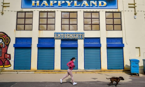 A woman jogs past a closed amusement arcade on a deserted Bournemouth promenade