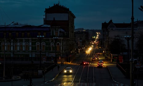 Cars transit along a road among residential buildings in the dark during a blackout in Kharkiv, northeastern Ukraine.