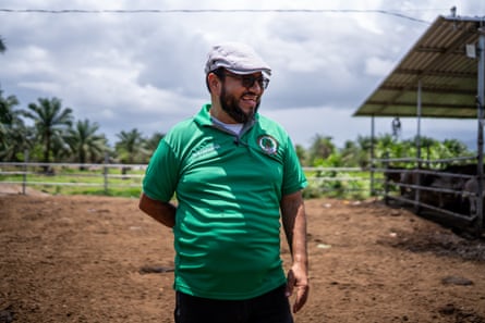 A honduran man in green T-shirt and pale grey flat cap