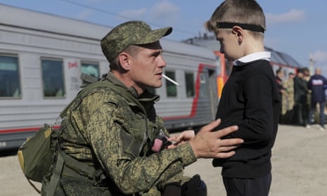 A Russian recruit speaks to his son before boarding a train at a station in the country’s Volgograd region