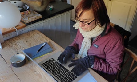 A woman works at home from her cold kitchen