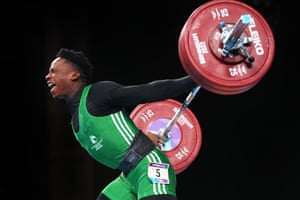 Edidiong Umoafia of Nigeria performs a snatch during the men’s 67kg final.