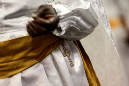 A cross sits on the waist of a worshipper as she prays during an Easter Sunday service.