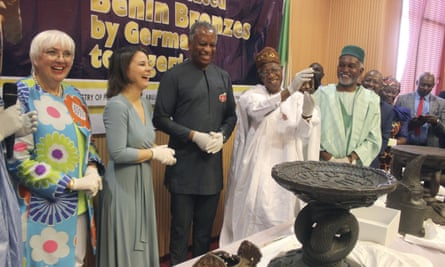 Nigerian culture minister, Lai Mohammed, second right, holds up one of the returned objects.
