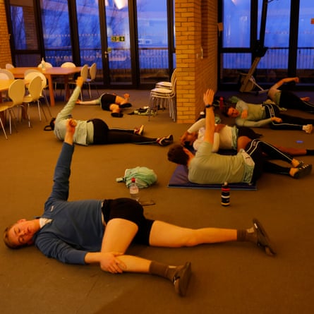 The Cambridge University Boat Club men’s squad stretch in the boathouse before an early morning training session at their Ely training site in Cambridgeshire.