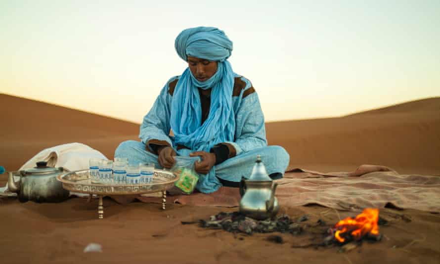 A Bedouin sitting in the dessert making tea