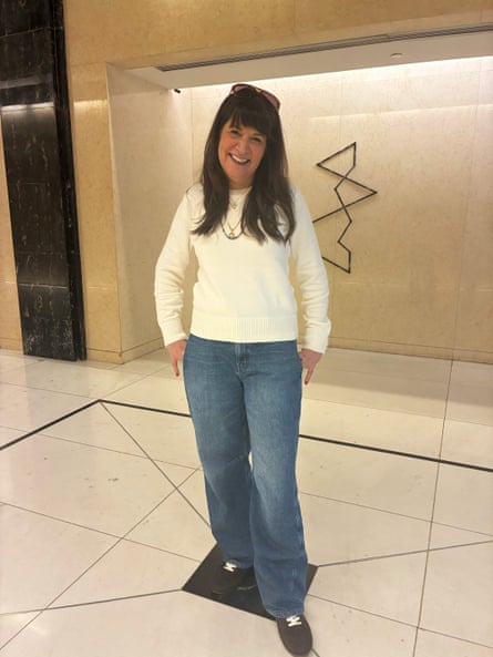 a woman in a white sweater and blue jeans