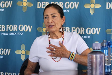 A middle-aged woman speaks with hand to chest