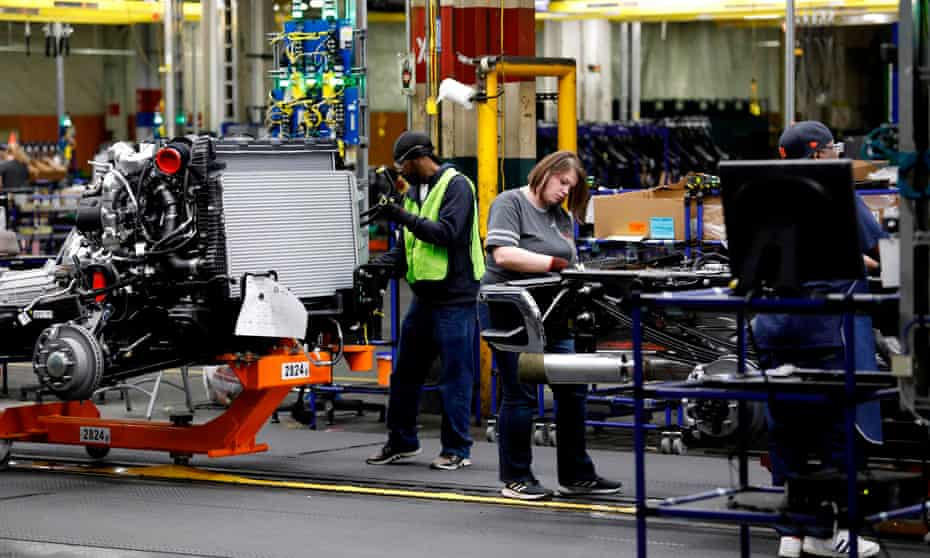 Workers work on General Motors pickup trucks in Flint, Michigan, in 2019.