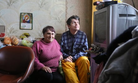 Liubov Prykhodko and her son Anatoliy sitting in the house that was damaged by a missile that struck their garden