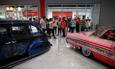 Visitors stand in front of 1939 Chevrolet Master Deluxe, named Gangster Squad ’39, left, and Jesse Valadez’s Gypsy Rose, a customized 1964 Chevrolet Impala, during an exhibition titled The High Art of Riding Low at the Petersen Automotive Museum in Los Angeles in 2017.