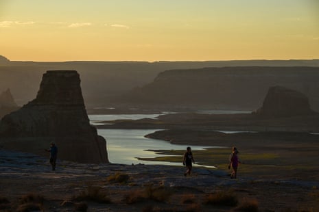Visitors watch the sunrise over Lake Powell from Alstrom Point in Big Water, Utah.