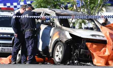 Police inspect the incinerated car