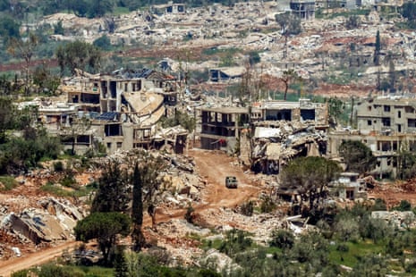 An Israeli military vehicle drives past houses destroyed in Israeli strikes in southern Lebanon.