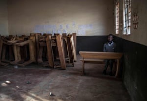 A student seats alone in a classroom after reporting back to school on day one of re-opening following an almost two-year closure to curb the spread of Covid-19 in Kampala.