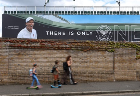 General view of people walking past a mural of Jannik Sinner outside the All England Lawn Tennis and Croquet Club