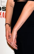 A close-up of Dua Lipa's forearms and hands, showing some of her tattoos