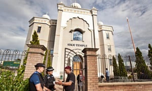 Police officers chat with a worshipper outside the Gurdwara Sahib, Leamington Spa