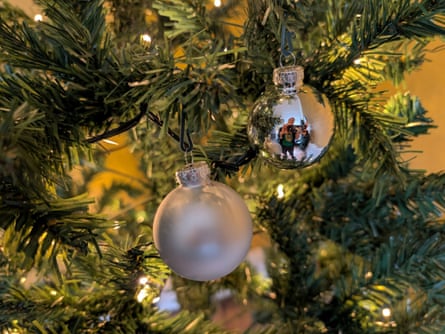 Closeup image of two silver baubles on an artificial Christmas tree.