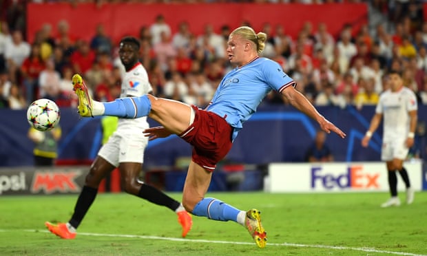 Erling Haaland rushes to open the scoring against Seville.