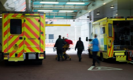 Ambulances parked outside a London hospital as NHS staff transport a patient on a gurney