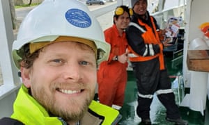 Reverend Dennis Woodward with two Filipino seafarers in the background