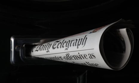 a daily telegraph newspaper rolled up and posted through a letterbox