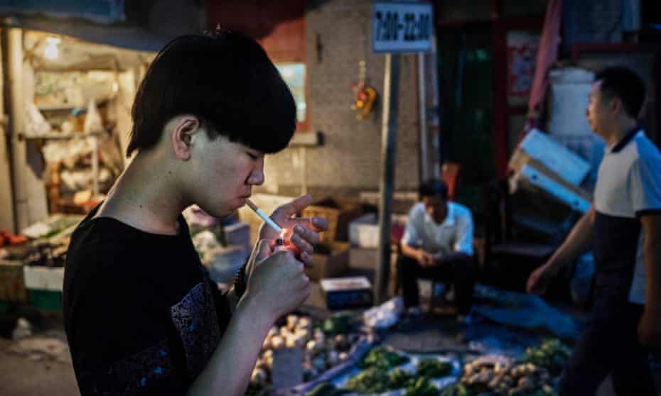 A man smokes in the street in Beijing, China