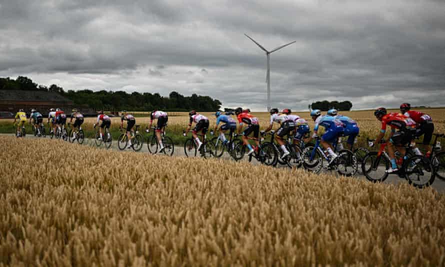 Wout Van Aert, wearing the yellow jersey leads the chasing peloton.
